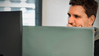 Ein Entwickler sitzt nachdenklich vor einem Bildschirm.